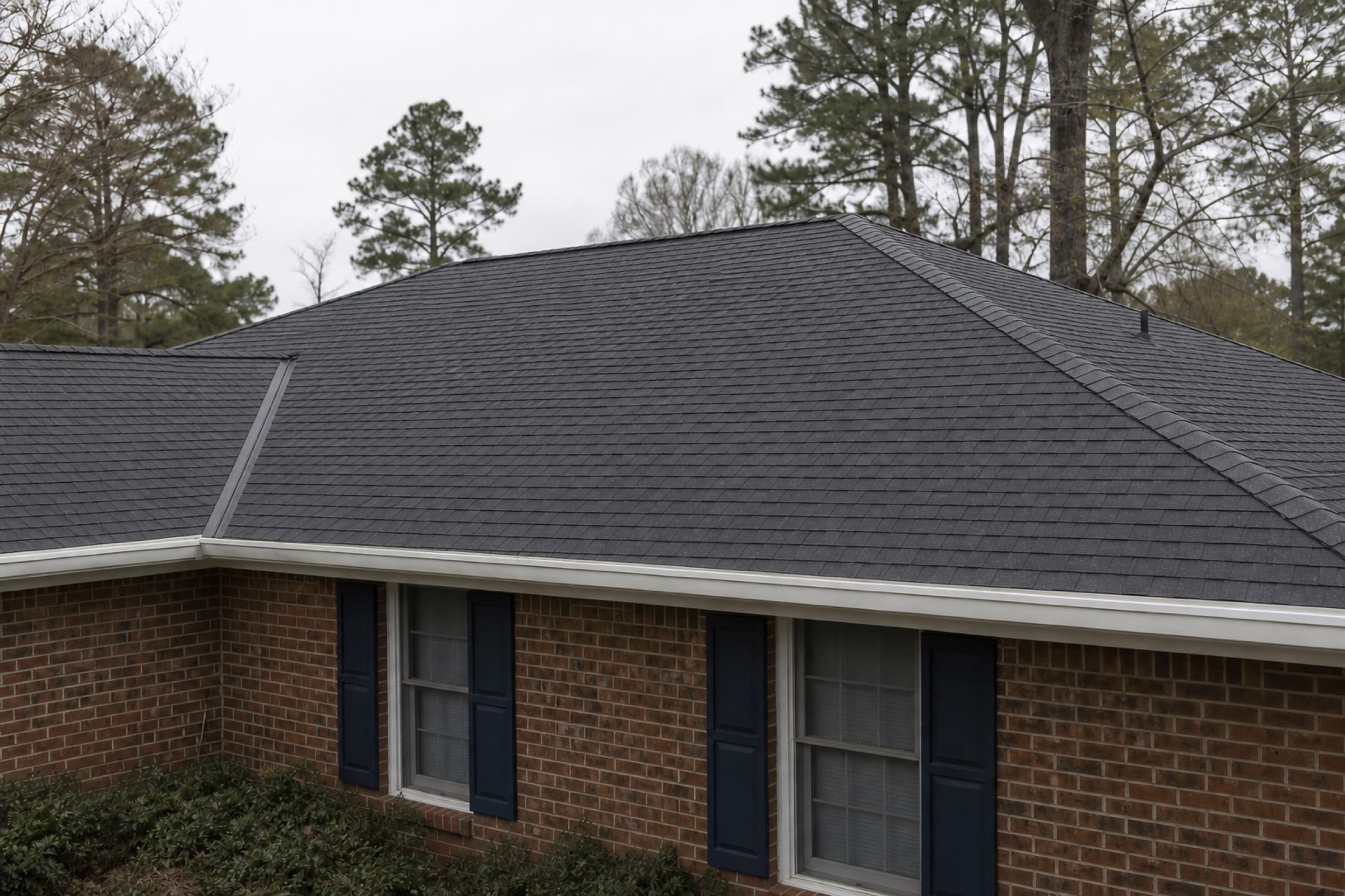 The same roof after replacement, with architectural shingles, new valley metal and a ridge vent